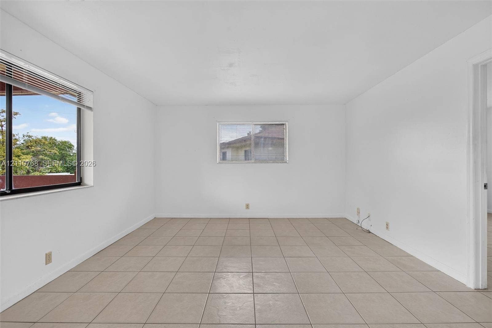 2070 NW 43rd Terrace, #7, Lauderhill, FL 33313 Neutral-toned ceramic tile flooring, clean white wall finishes, and multiple windows providing natural light
