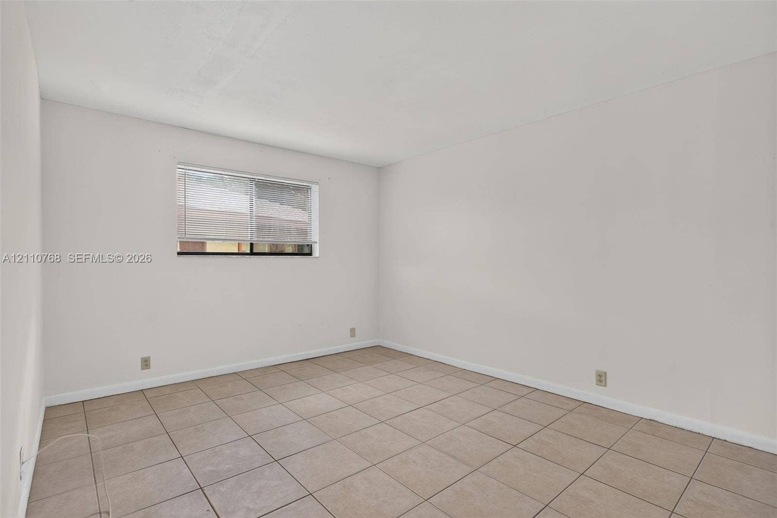 2070 NW 43rd Terrace, #7, Lauderhill, FL 33313 Neutral interior space featuring ceramic tile flooring, neutral wall tones, and a single sliding window