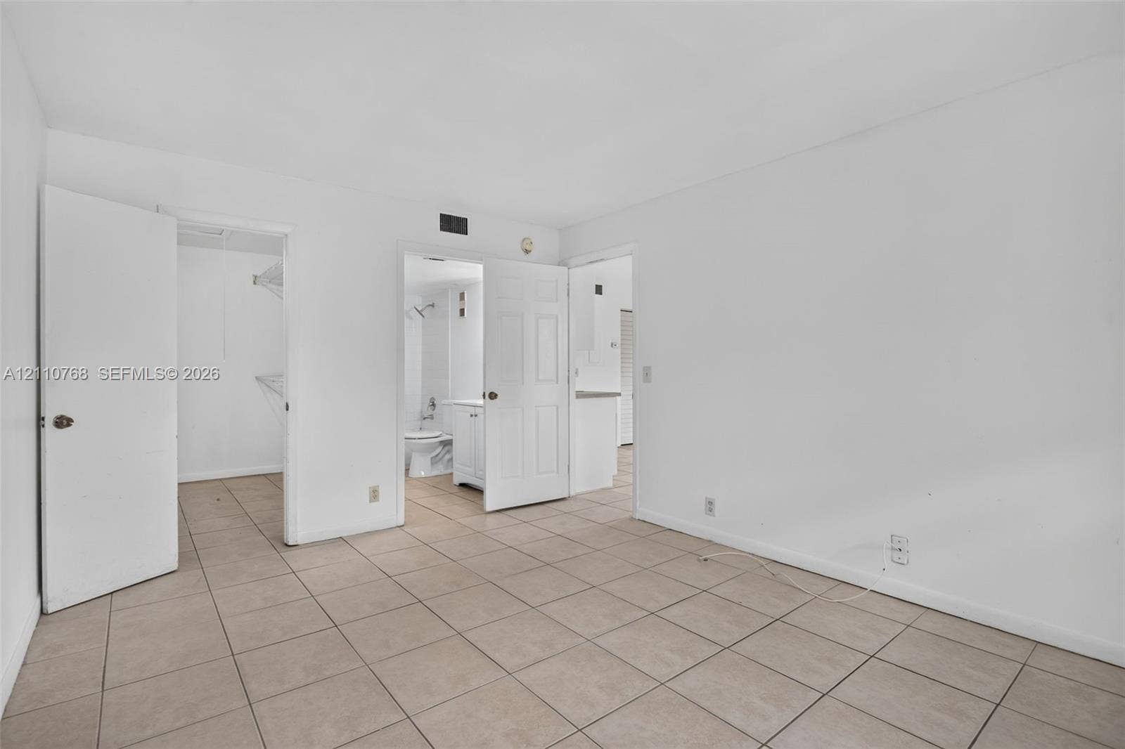 2070 NW 43rd Terrace, #7, Lauderhill, FL 33313 Neutral-toned ceramic tile flooring, walk-in closet with built-in wire shelving, and solid-core interior doors