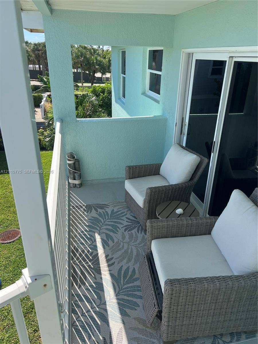 4995 S Highway A1a, #D, Melbourne Beach, FL 32951 Private balcony featuring stucco walls, a metal railing, and sliding glass door access
