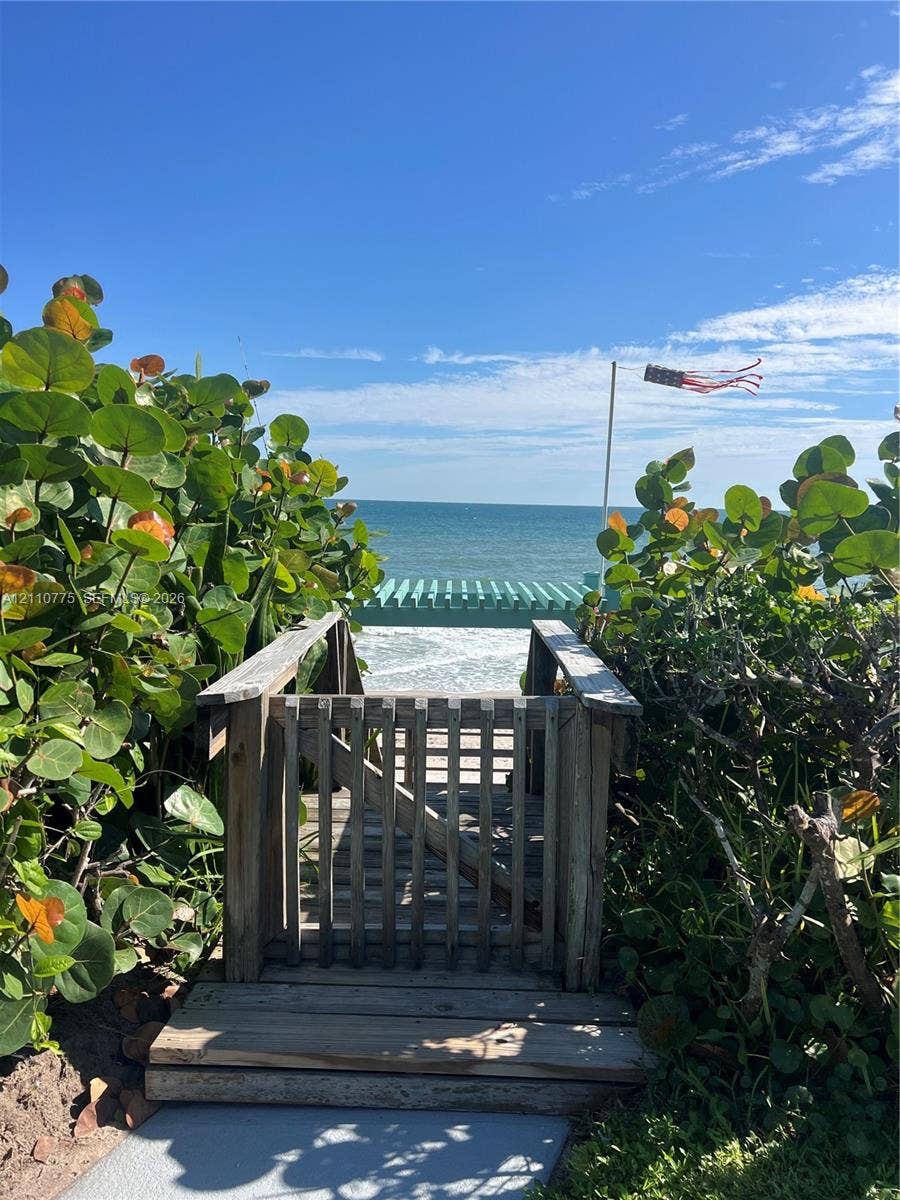 4995 S Highway A1a, #D, Melbourne Beach, FL 32951 Private wooden beach access gate with a path leading to a timber pergola overlooking the ocean