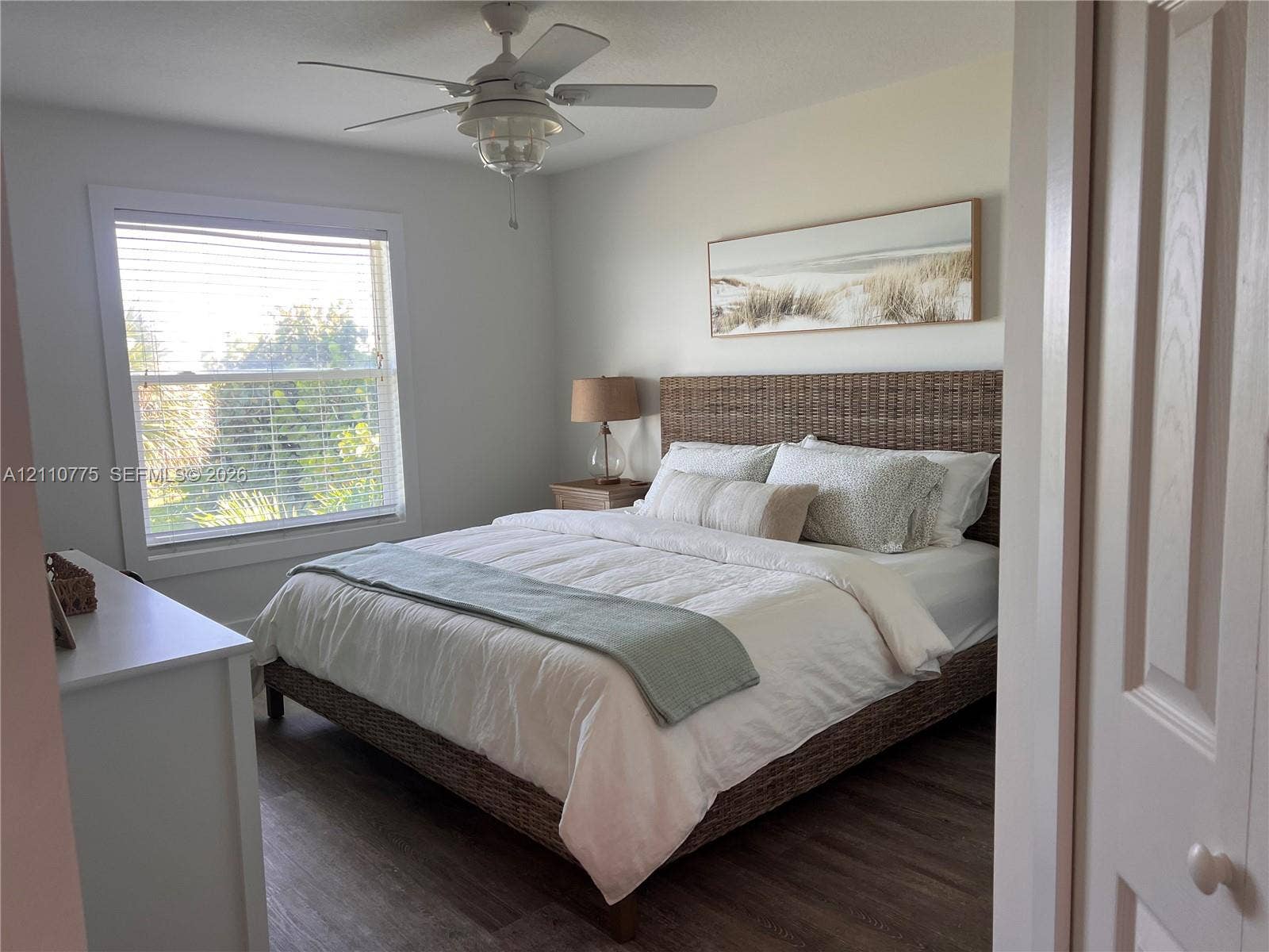 4995 S Highway A1a, #D, Melbourne Beach, FL 32951 Wood-finish flooring, ceiling fan with integrated lighting, and window with horizontal blinds