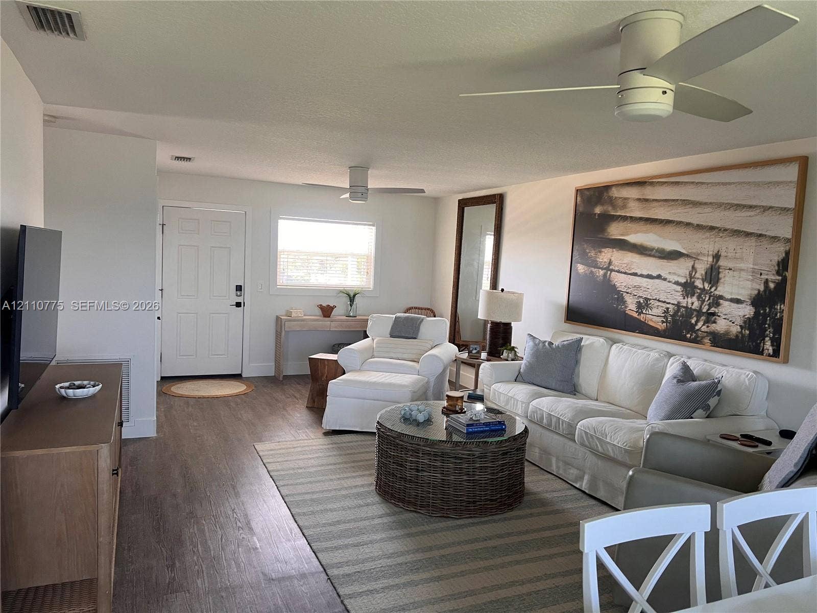 4995 S Highway A1a, #D, Melbourne Beach, FL 32951 Open-concept room featuring wood-finish flooring, neutral wall paint, and dual ceiling fans