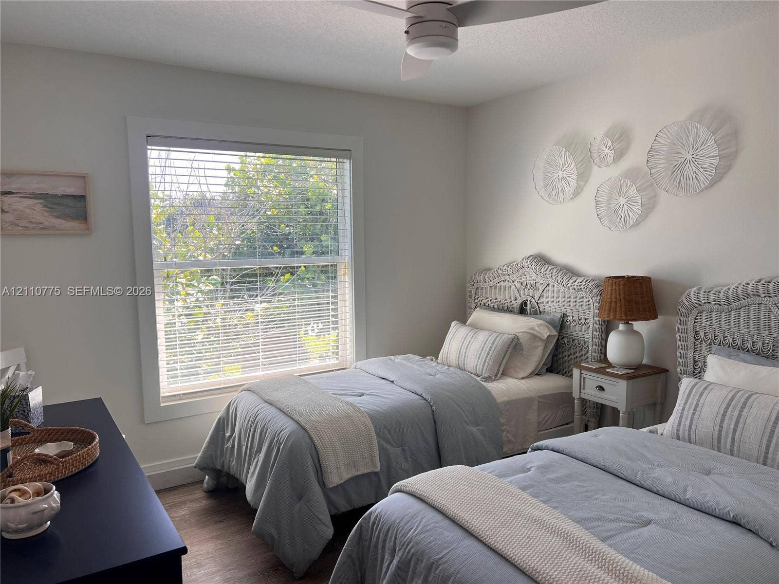 4995 S Highway A1a, #D, Melbourne Beach, FL 32951 Large window with white casing, wood-finish flooring, and ceiling-mounted fan with integrated lighting