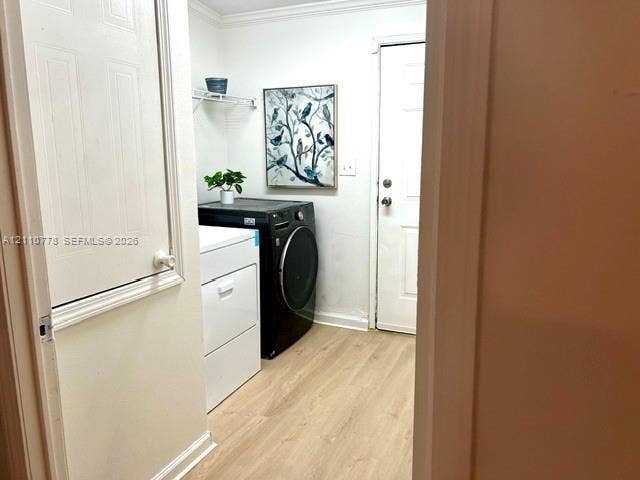 Utility area featuring wood-finish flooring, a white paneled door, and built-in overhead wire shelving