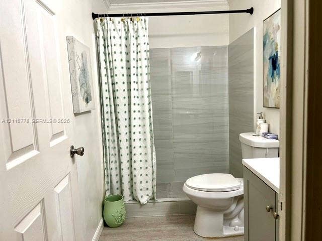 Bathroom featuring a walk-in shower with grey horizontal-tile surround, vanity with stone-top surface, and wood-finish flooring