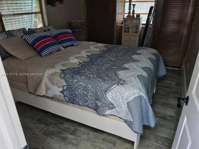 Wood-finish tile flooring, dual louvered-door closets, and windows with integrated blinds