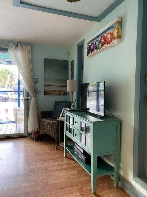Interior space featuring wood-finish flooring, glass-paned door, and contrasting painted trim