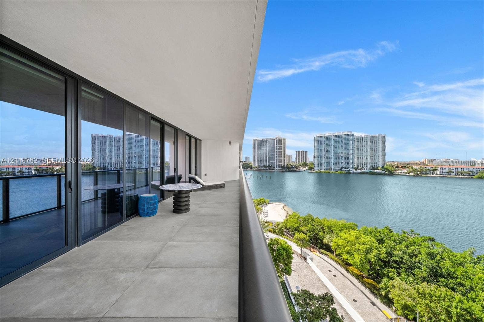 Expansive covered terrace featuring large-format tile flooring and full-height black-framed glass sliding doors