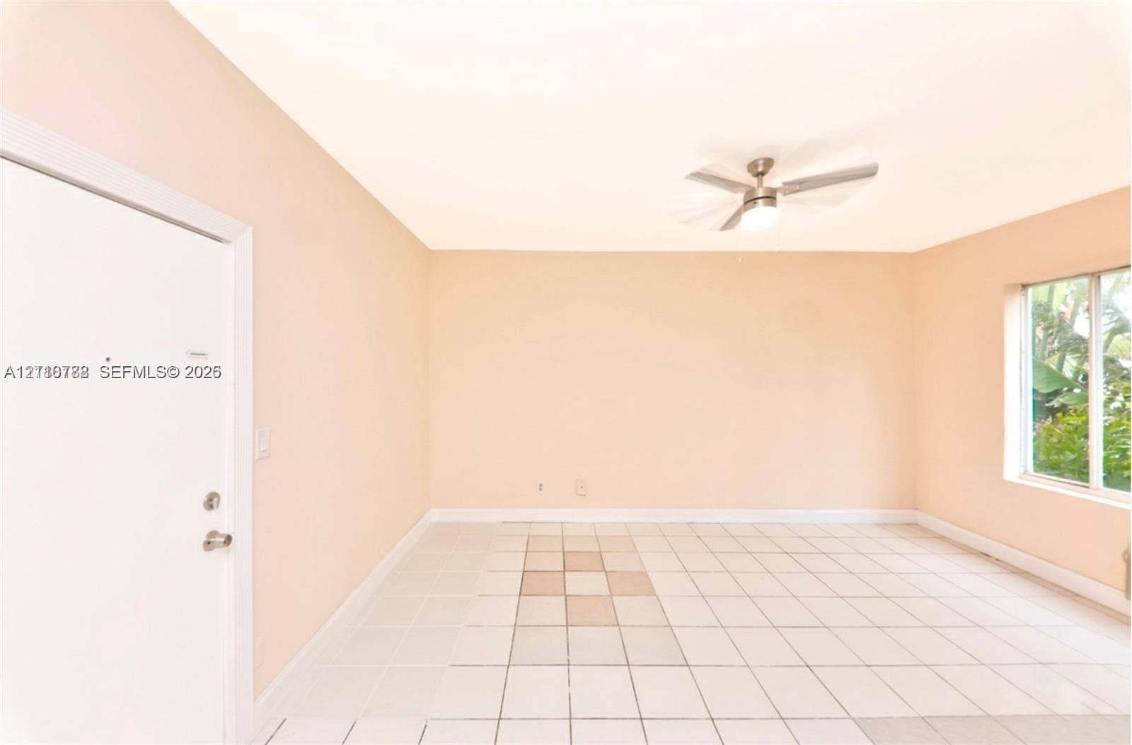 3710 Collins Avenue, #N-202, Miami Beach, FL 33140 Neutral interior room featuring white tile flooring, a multi-blade ceiling fan with integrated lighting, and a single-pane window