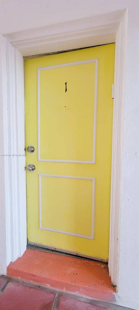 Solid-core door featuring a two-panel design, decorative molding, dual metallic hardware, and a metal threshold