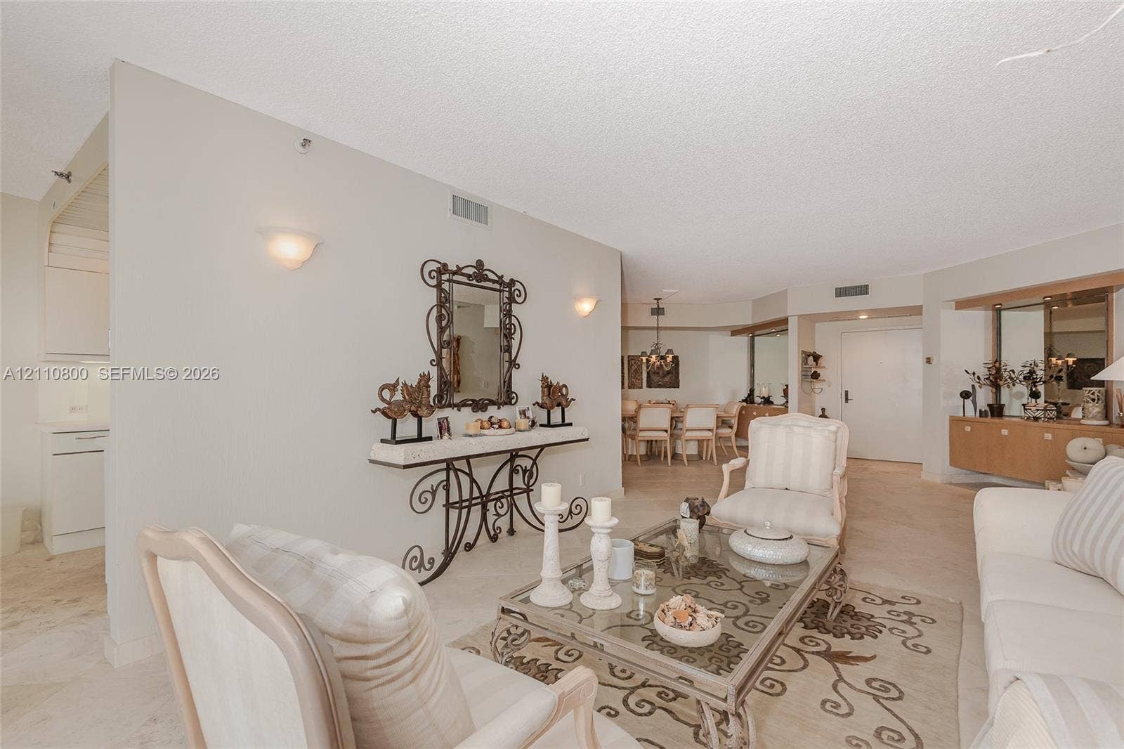 Open-concept interior featuring neutral stone-finish tile flooring, recessed lighting, and wall-mounted sconce fixtures