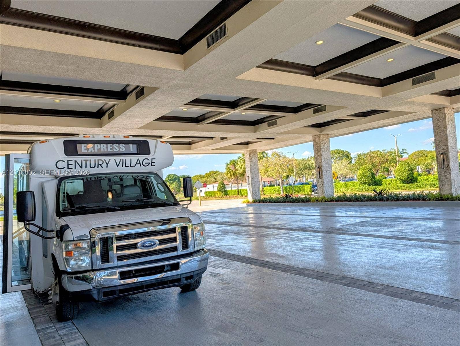 Covered porte-cochere featuring a coffered ceiling, stone-clad pillars, and recessed lighting