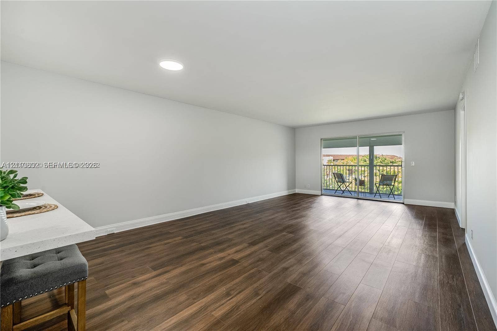 Open-concept living space featuring wood-finish flooring, recessed lighting, and sliding glass doors with exterior access