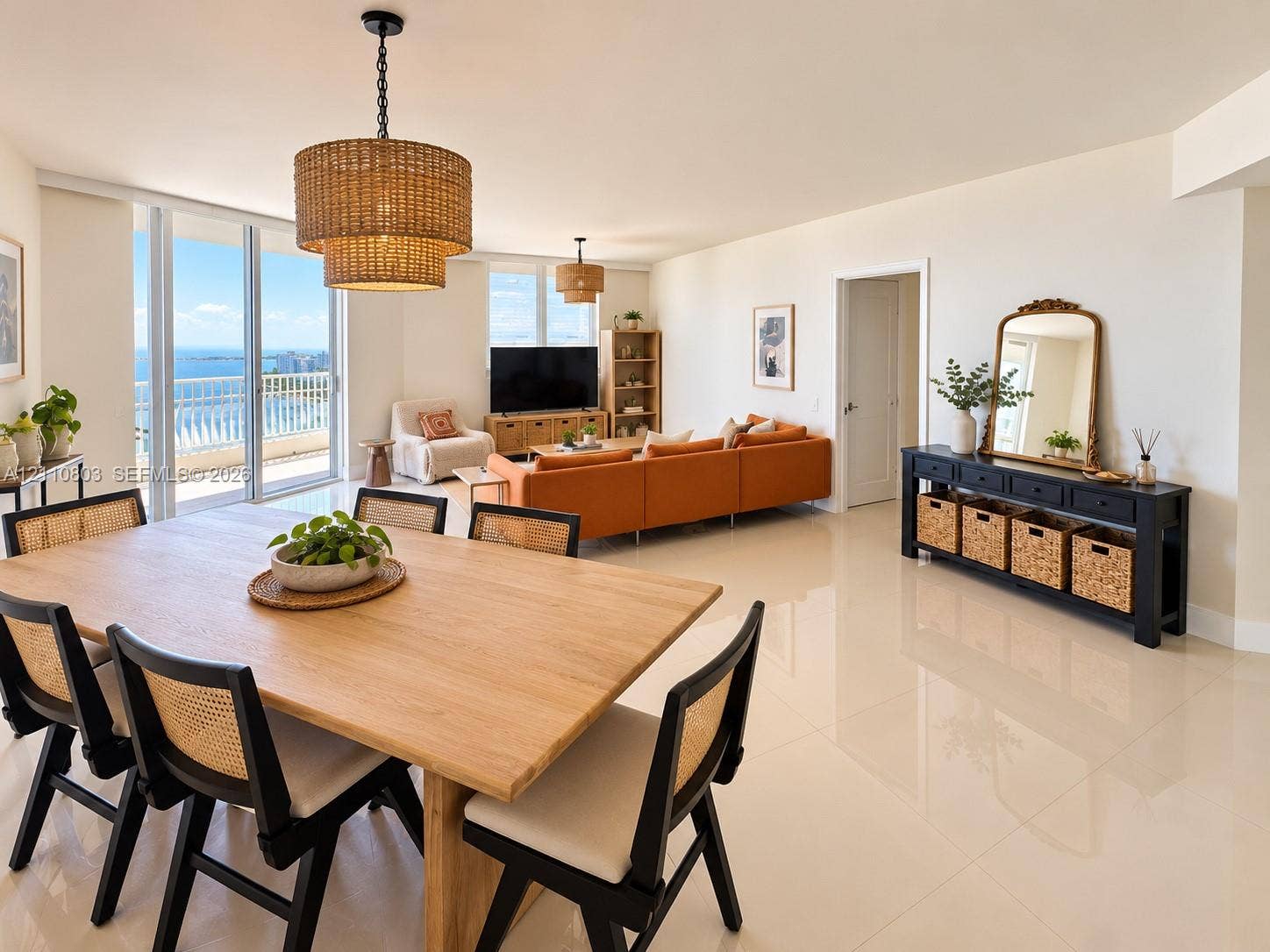 Open-concept floor plan featuring polished tile flooring, floor-to-ceiling glass doors, and dual tiered woven pendant light fixtures