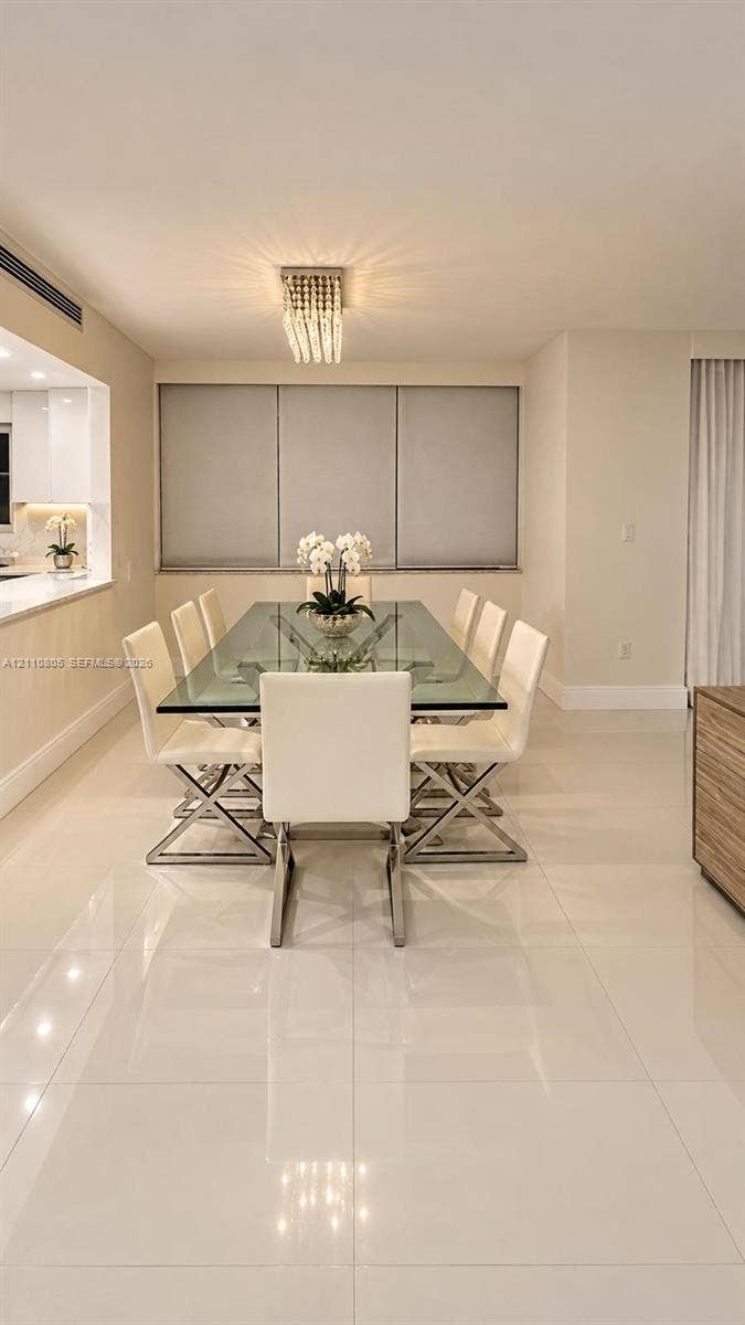 Large-format polished tile flooring, bead-style crystal flush-mount light fixture, and pass-through counter with integrated surface