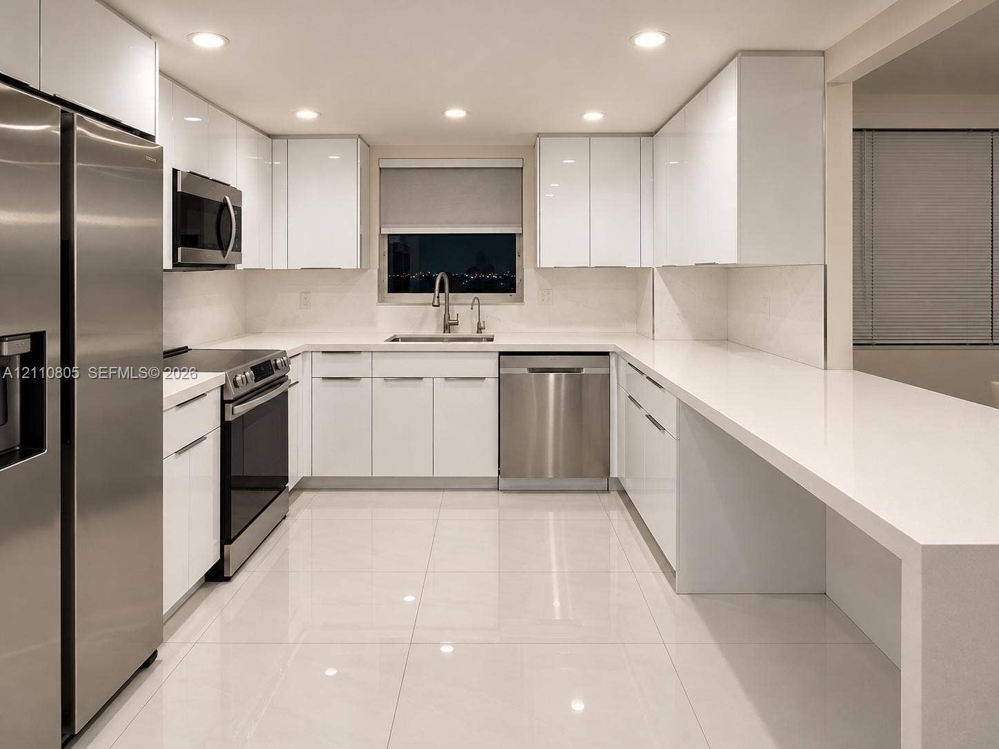 Kitchen featuring white gloss cabinetry, stainless steel appliances, solid surface countertops, recessed lighting, and tile flooring