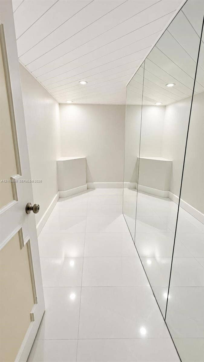 Glossy tile flooring, shiplap ceiling, full-length wall mirror, and recessed lighting
