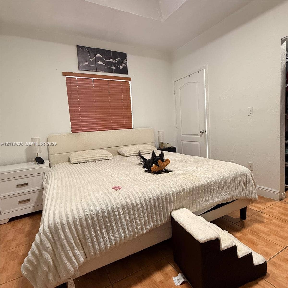 Room interior featuring neutral walls, recessed ceiling detail, and wood-finish tile flooring