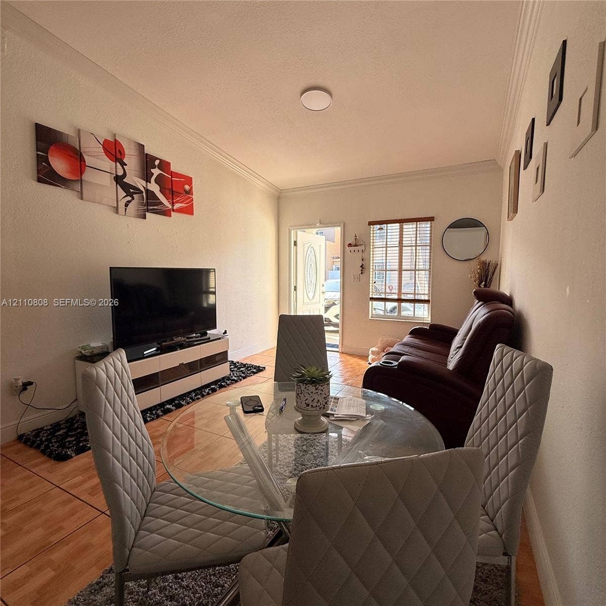 Ceramic tile flooring, crown molding, and an exterior door with a decorative glass insert