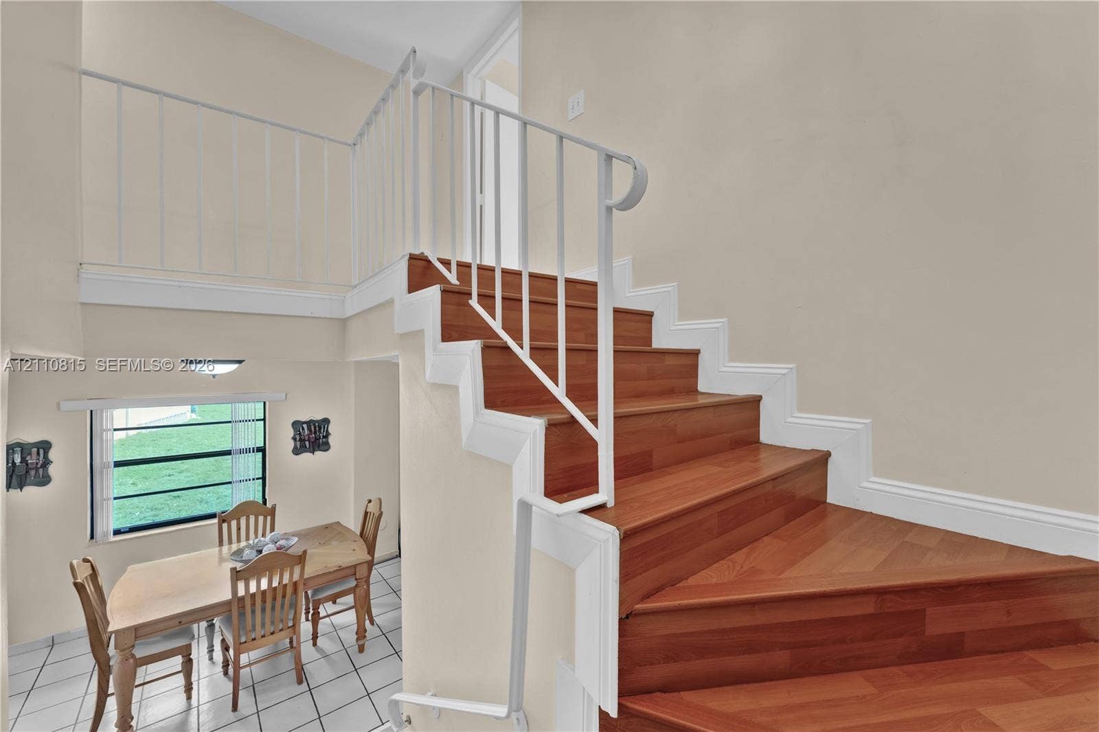9100 Orchid Tree Lane, #137, Pembroke Pines, FL 33024 Staircase featuring wood-finish treads, white painted risers, and a white metal railing