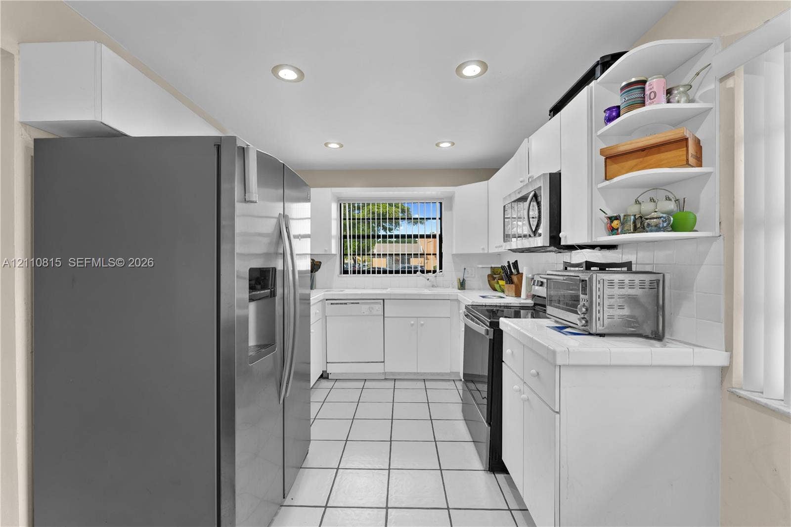 9100 Orchid Tree Lane, #137, Pembroke Pines, FL 33024 Kitchen featuring white cabinetry, stainless steel appliances, ceramic tile flooring, and recessed ceiling lighting