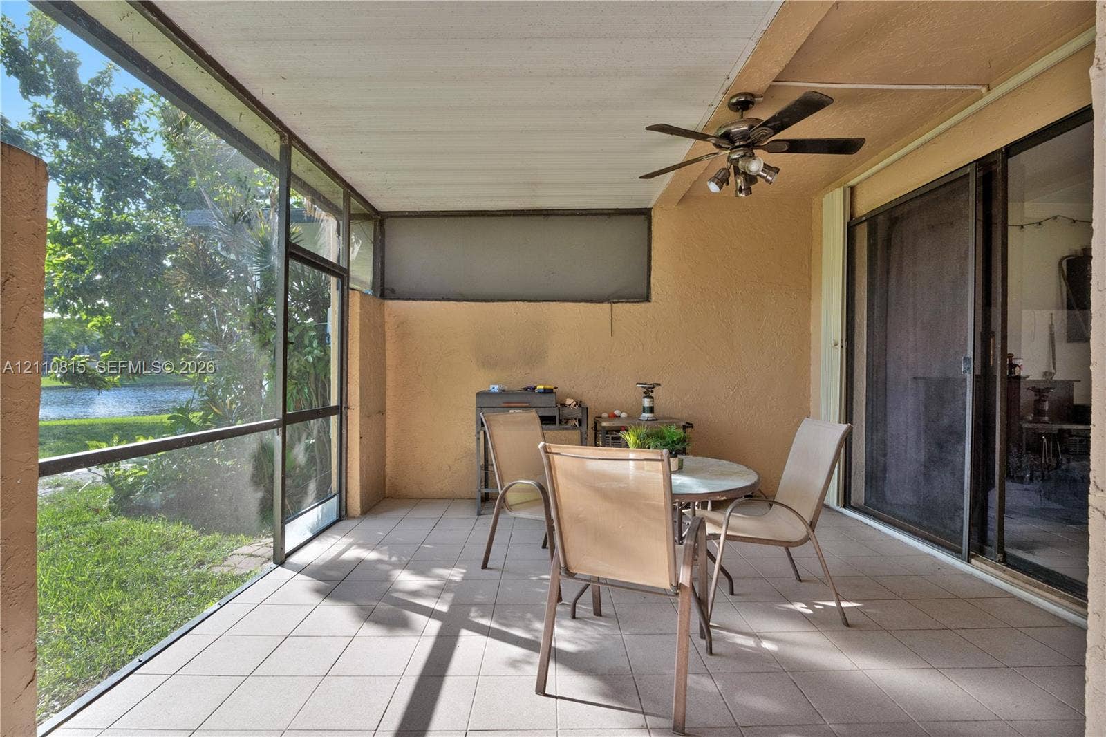 9100 Orchid Tree Lane, #137, Pembroke Pines, FL 33024 Screened-in patio featuring tiled flooring, a ceiling fan with integrated lighting, and direct access to the exterior through sliding glass doors