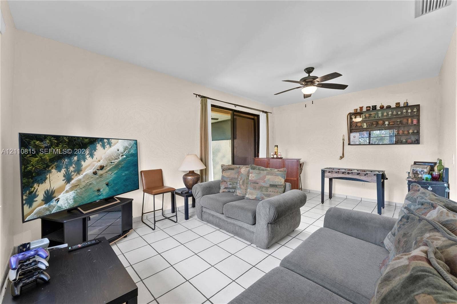 9100 Orchid Tree Lane, #137, Pembroke Pines, FL 33024 Ceramic tile flooring, ceiling fan with integrated lighting, and sliding glass door