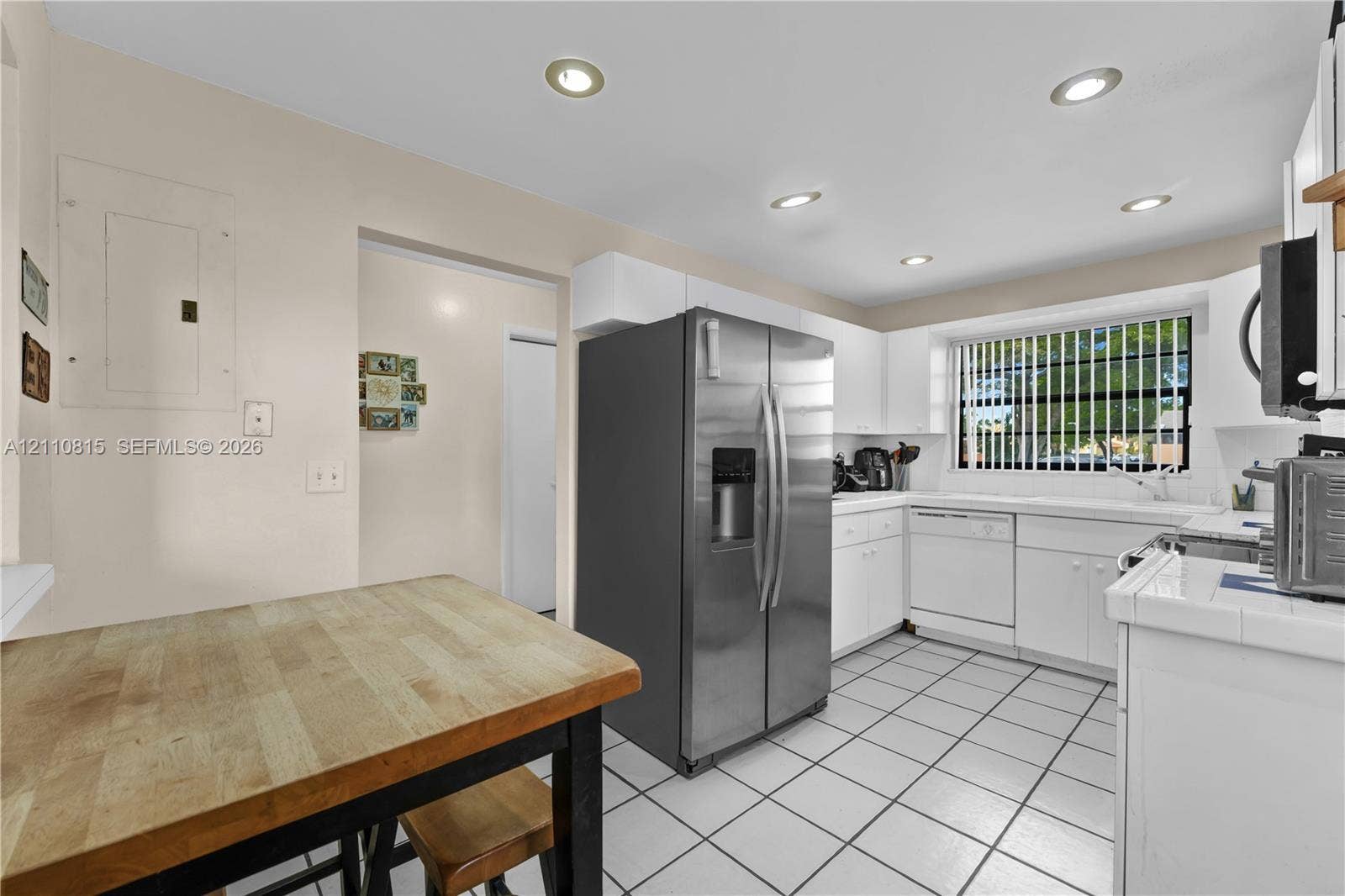 9100 Orchid Tree Lane, #137, Pembroke Pines, FL 33024 Kitchen featuring white cabinetry, stainless steel side-by-side refrigerator, recessed lighting, and tile flooring