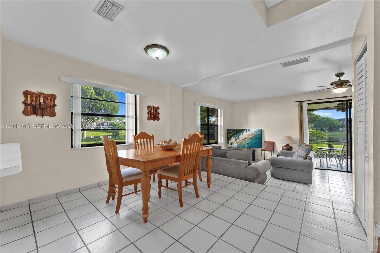 9100 Orchid Tree Lane, #137, Pembroke Pines, FL 33024 Living area featuring tile flooring, ceiling fans, recessed lighting, and multiple windows providing natural light, inclusive of a sliding glass door to exterior space