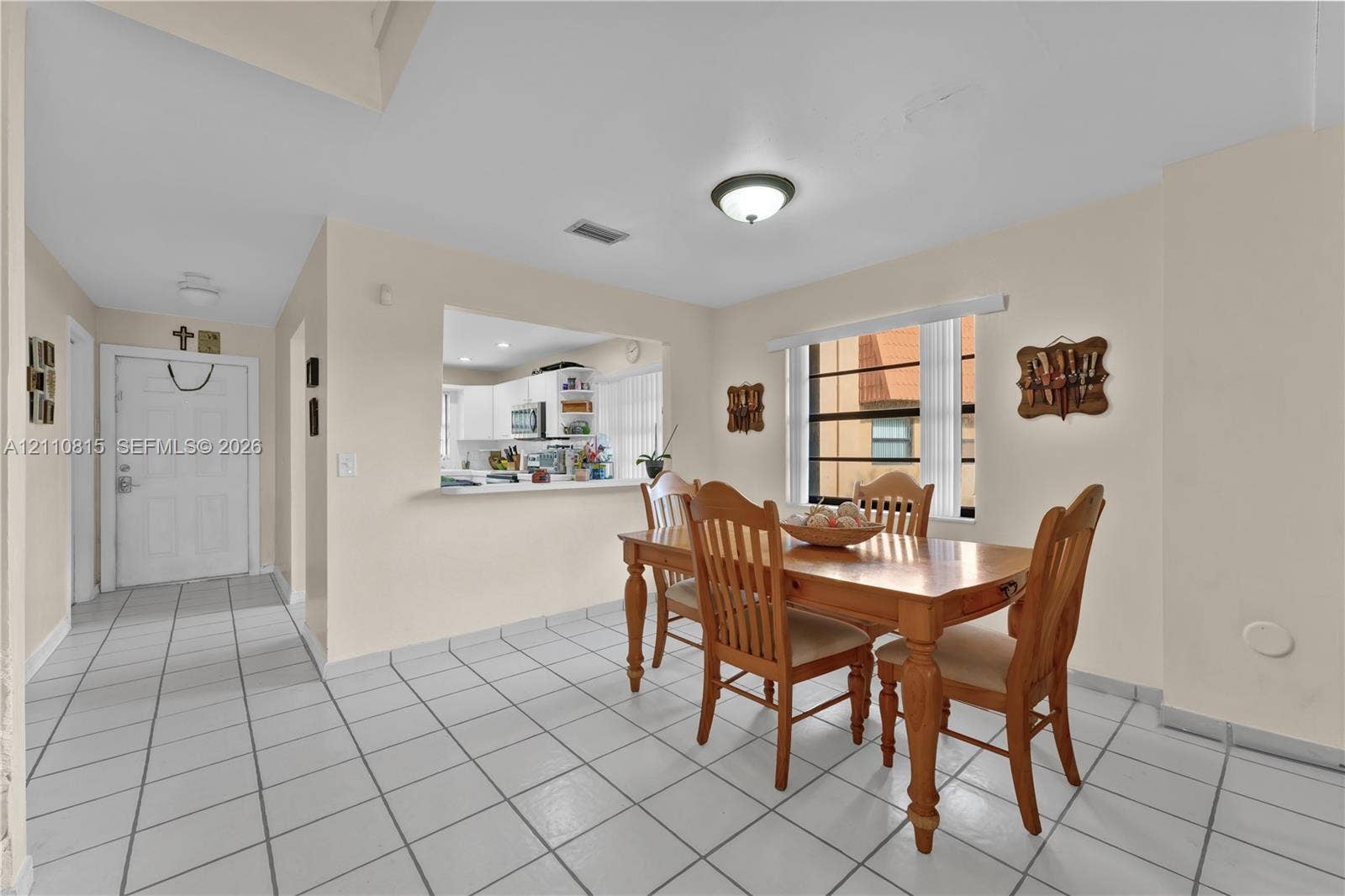 9100 Orchid Tree Lane, #137, Pembroke Pines, FL 33024 Interior space featuring large-format tile flooring, a pass-through window to the kitchen, and a window with horizontal blinds