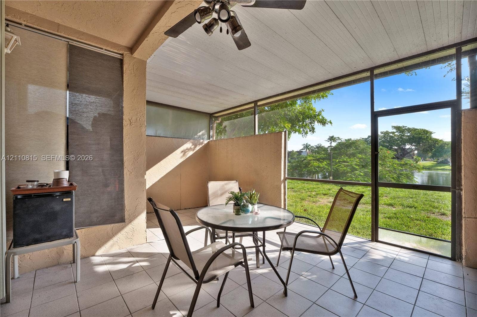 9100 Orchid Tree Lane, #137, Pembroke Pines, FL 33024 Screened-in patio featuring white tile flooring, beadboard ceiling, overhead ceiling fan, and structural enclosure with aluminum framing