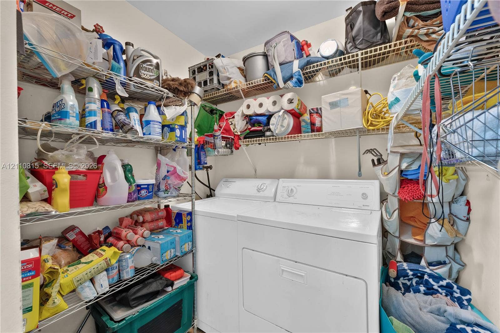 9100 Orchid Tree Lane, #137, Pembroke Pines, FL 33024 Laundry area featuring white top-load washer and dryer with multi-level wire shelving