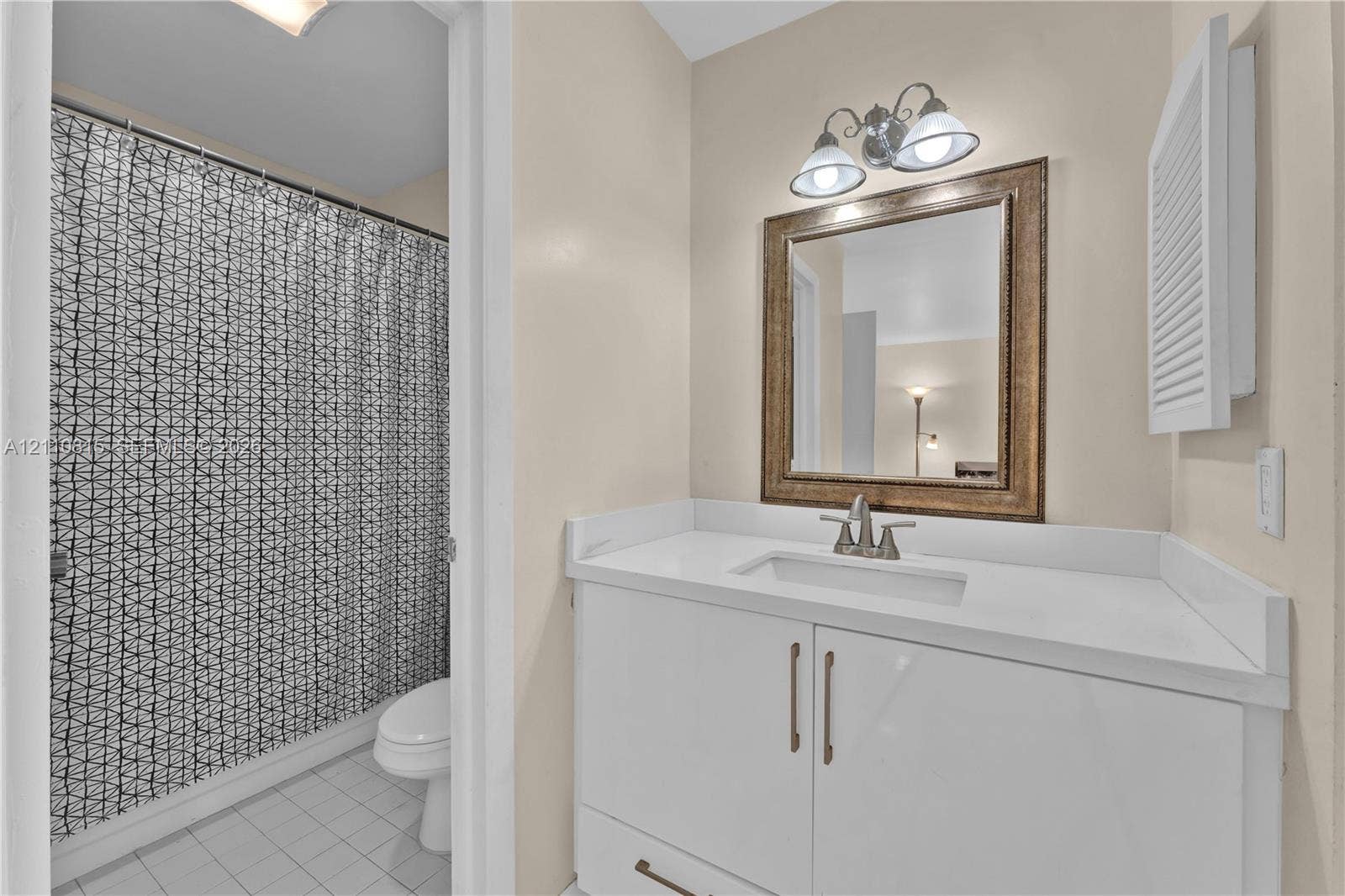 9100 Orchid Tree Lane, #137, Pembroke Pines, FL 33024 White vanity with integrated rectangular sink, solid surface countertop, two-light vanity fixture, and recessed medicine cabinet
