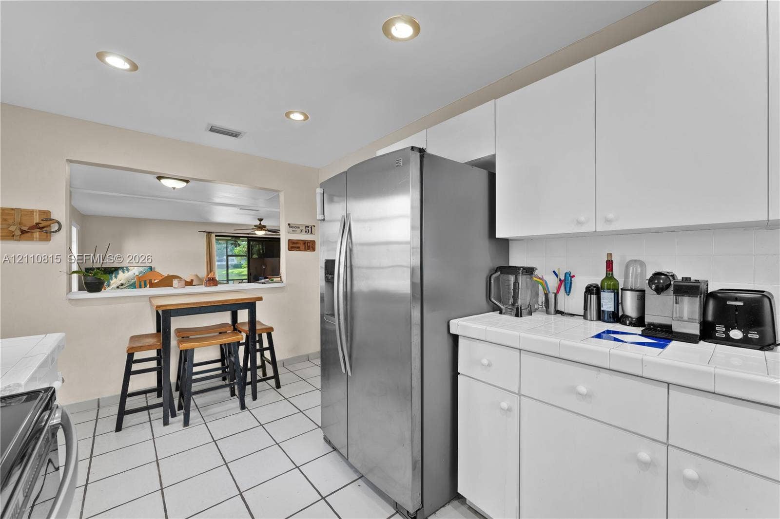 9100 Orchid Tree Lane, #137, Pembroke Pines, FL 33024 Kitchen featuring white cabinetry, ceramic tile countertops, stainless steel side-by-side refrigerator, ceramic tile flooring, and recessed ceiling lighting