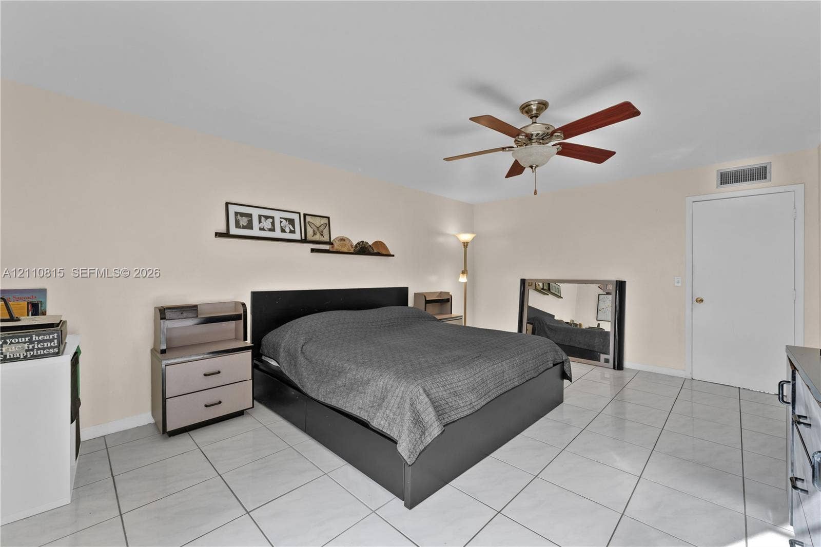9100 Orchid Tree Lane, #137, Pembroke Pines, FL 33024 Neutral-toned room featuring large-format ceramic tile flooring, a centered ceiling fan with integrated lighting, and a white interior door