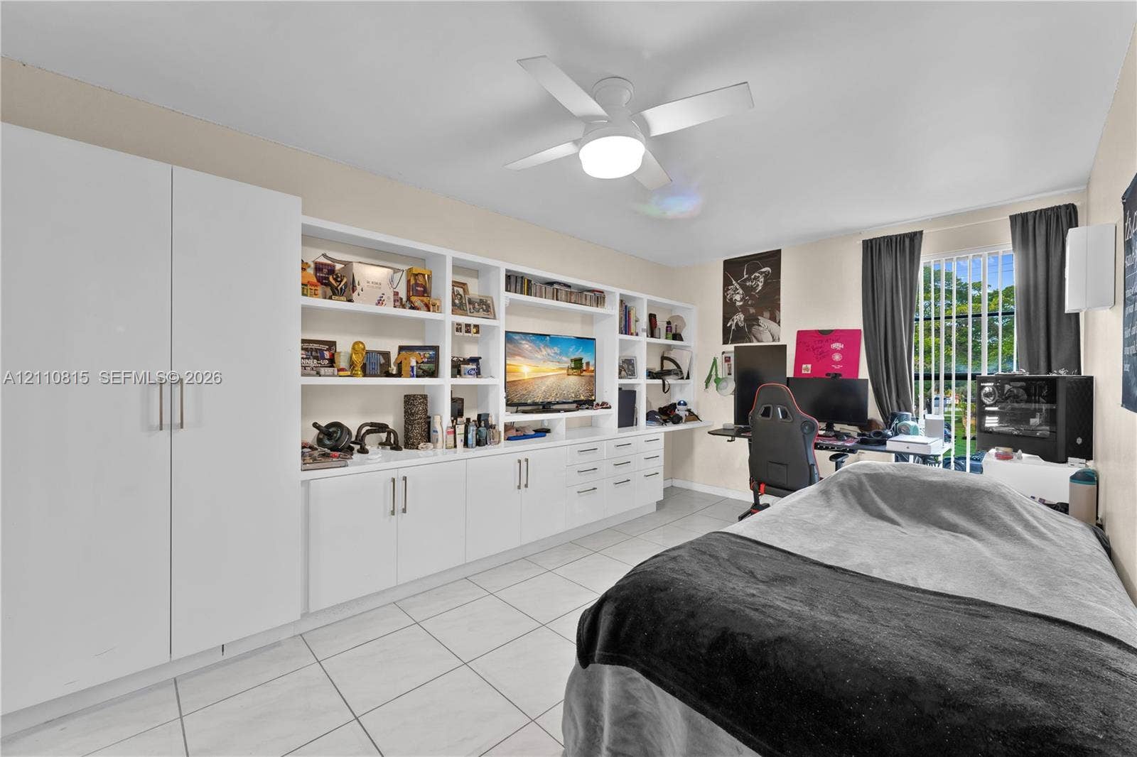 9100 Orchid Tree Lane, #137, Pembroke Pines, FL 33024 Wall-to-wall built-in cabinetry featuring white shaker-style doors, open display shelving, and integrated drawers, complete with tile flooring and a ceiling-mounted light fixture