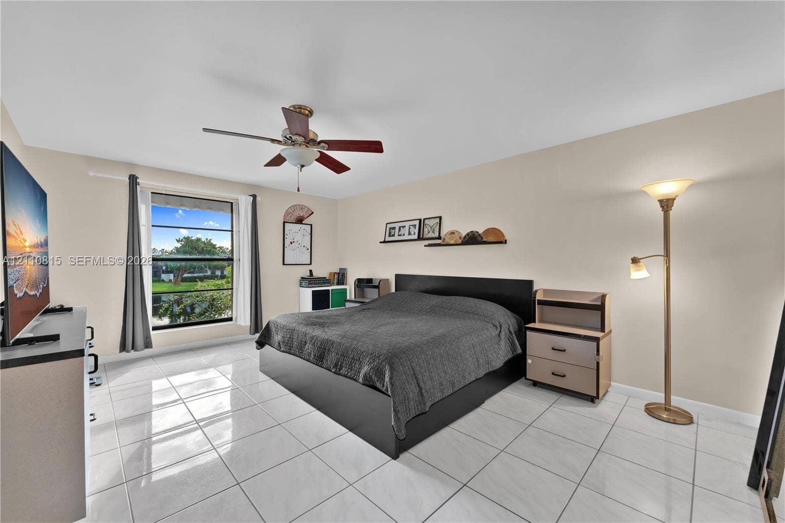 9100 Orchid Tree Lane, #137, Pembroke Pines, FL 33024 Neutral tile flooring, ceiling fan with light fixture, and large window