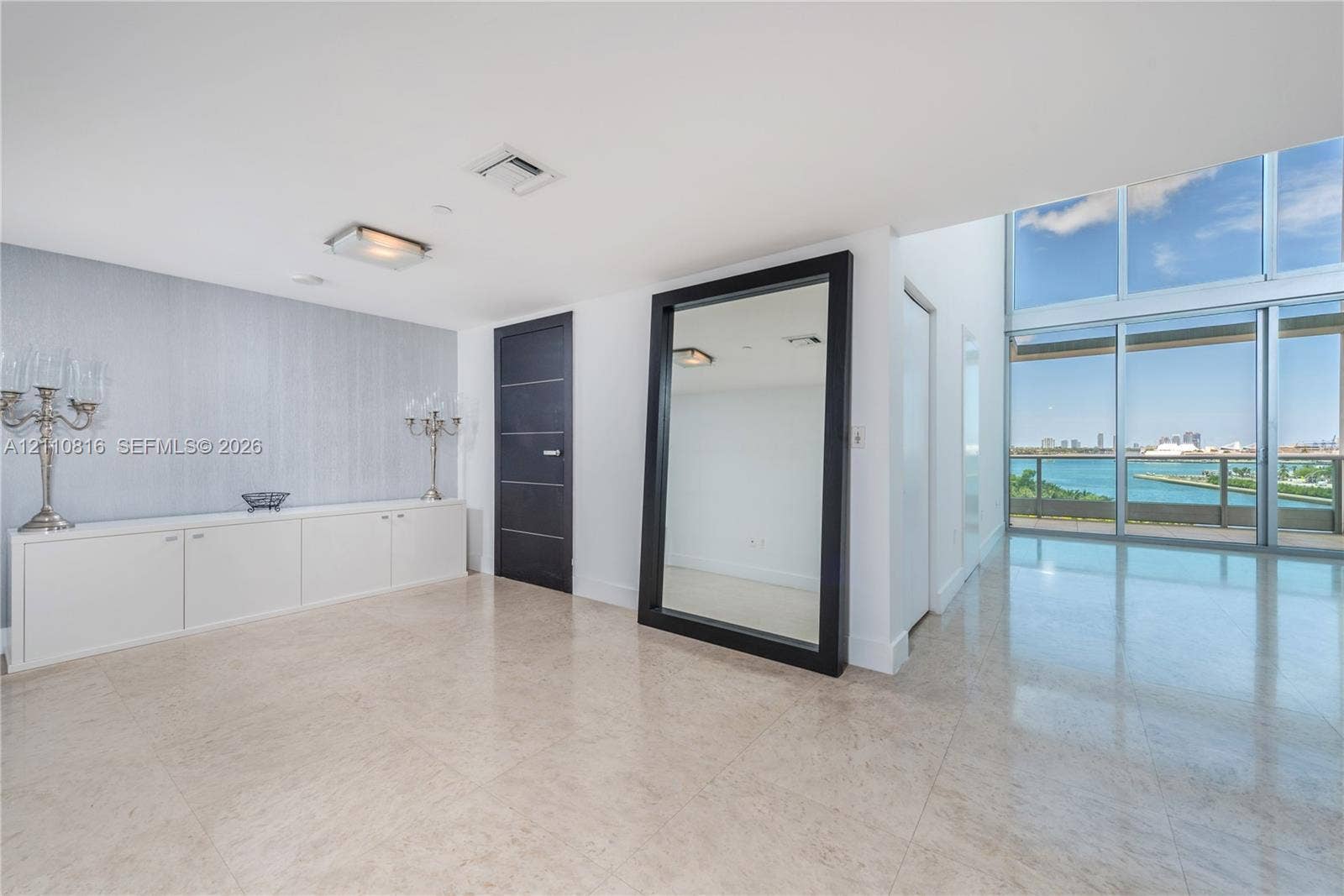 Floor-to-ceiling windows, stone flooring, built-in cabinetry, and neutral-toned wall finish