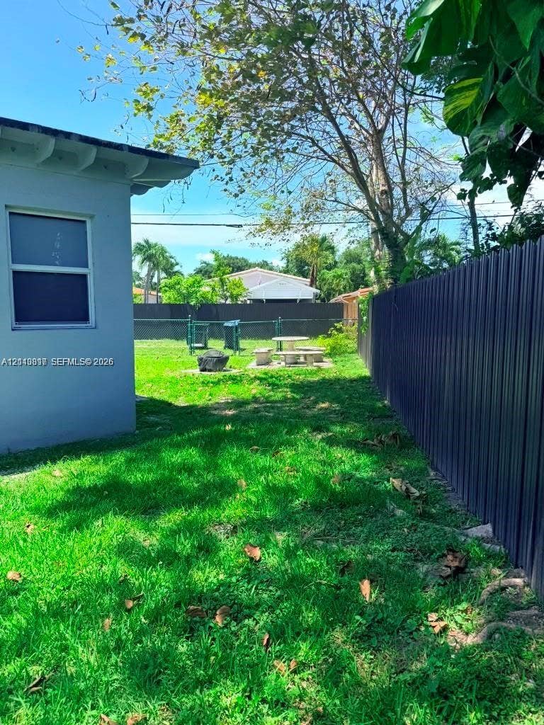 201 Flagler Drive, #201, Miami Springs, Miami Springs, FL 33166 Backyard featuring a grass lawn, metal privacy fencing, and mature trees