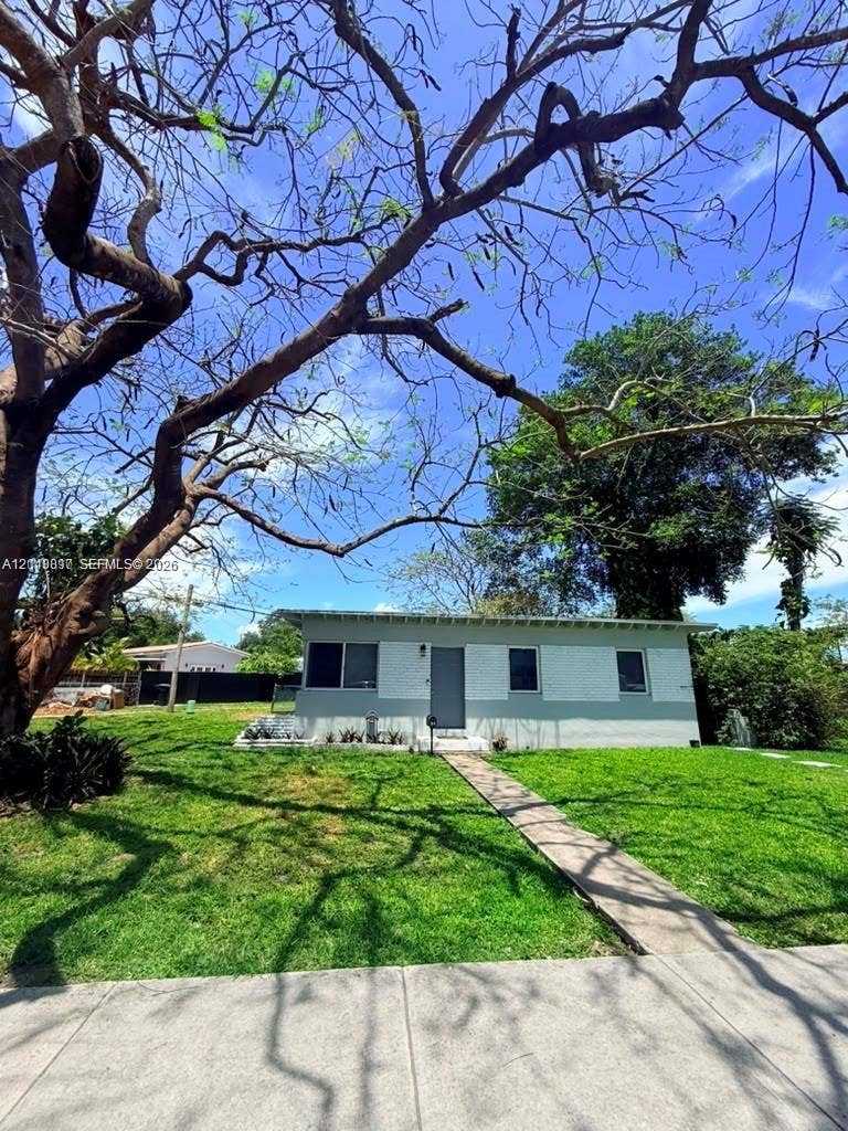 201 Flagler Drive, #201, Miami Springs, Miami Springs, FL 33166 Exterior facade featuring painted brick masonry, concrete walkway, and mature landscape