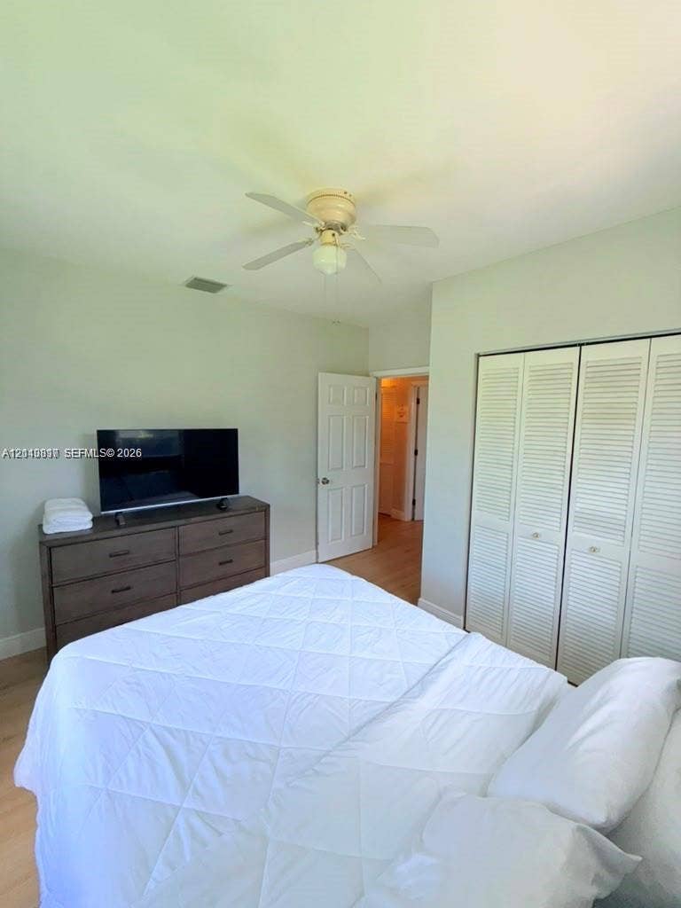 201 Flagler Drive, #201, Miami Springs, Miami Springs, FL 33166 Room featuring wood-finish flooring, a ceiling fan, and louvered closet doors