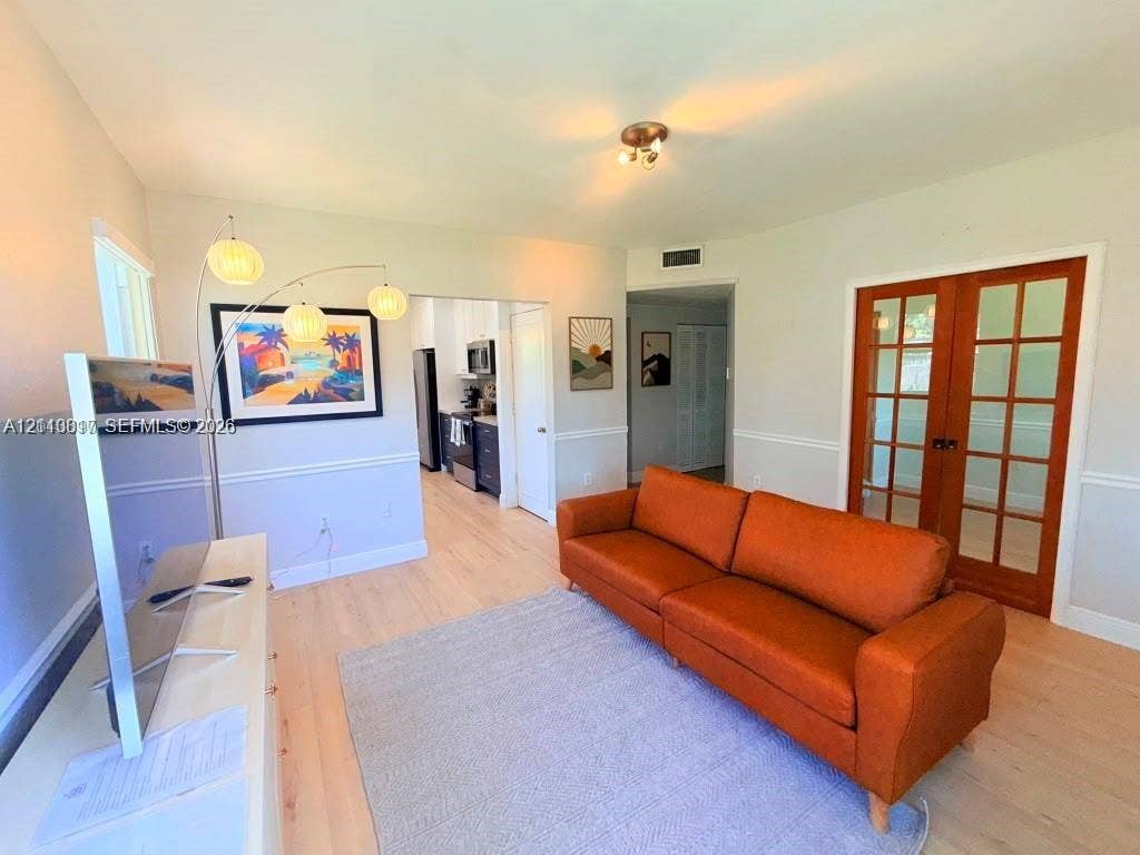 201 Flagler Drive, #201, Miami Springs, Miami Springs, FL 33166 Light-toned wood-finish flooring, white chair rail molding, and French doors with wood frames