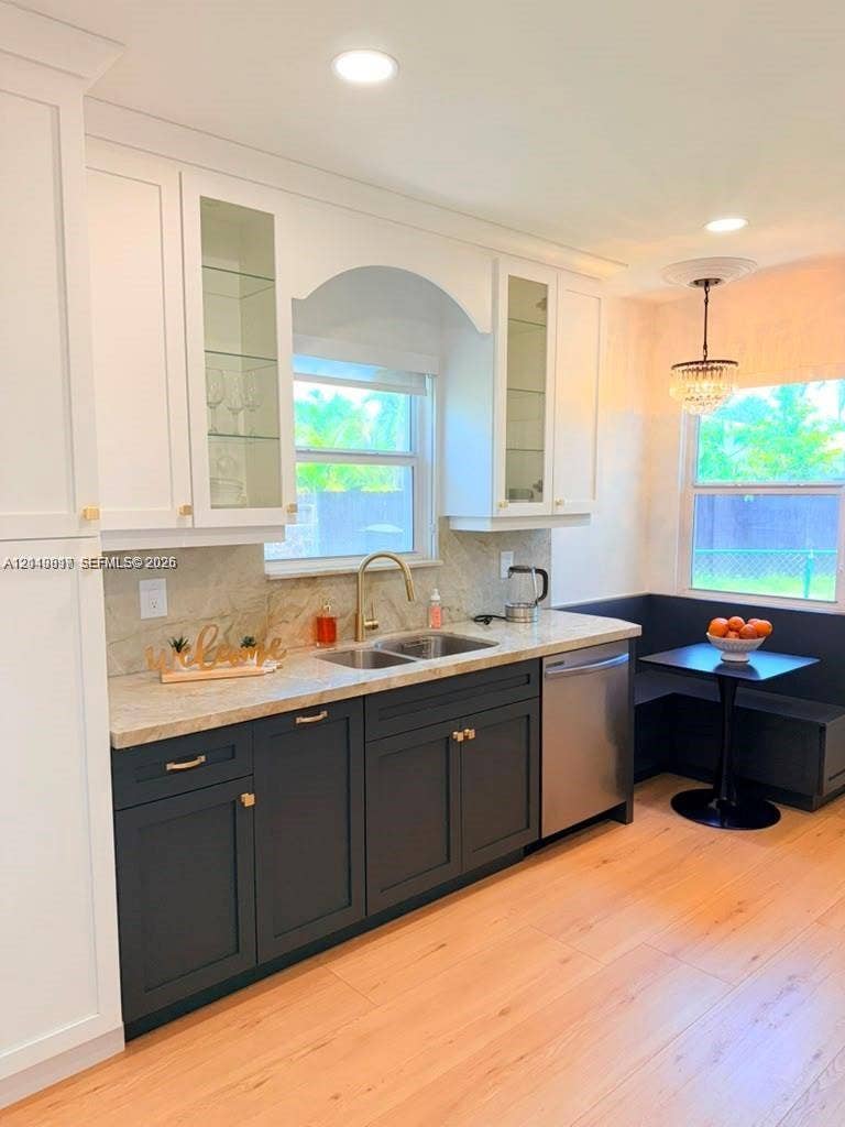 201 Flagler Drive, #201, Miami Springs, Miami Springs, FL 33166 Two-toned cabinetry with glass-front display uppers, light-toned stone countertops, integrated stainless steel dishwasher, brass-finish faucet, and recessed lighting