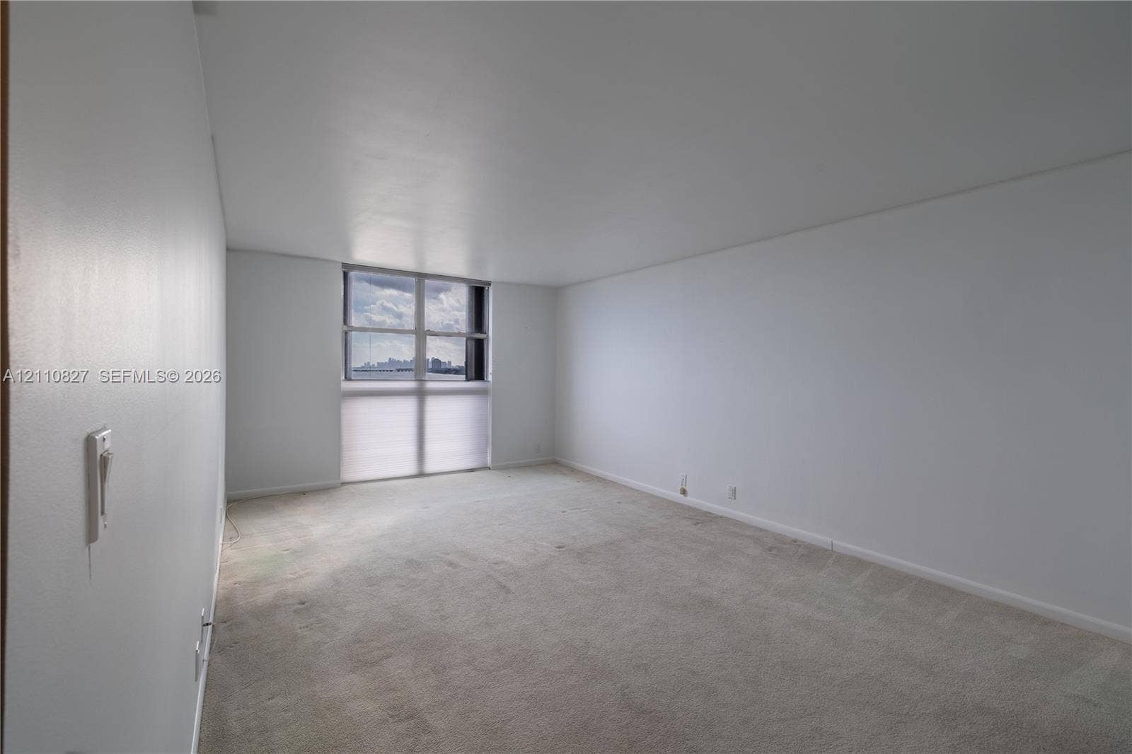4000 Towerside Terrace, #908, Miami, Miami, FL 33138 Neutral-toned interior space featuring light-colored wall-to-wall carpeting, expansive wall space, and a floor-to-ceiling window configuration