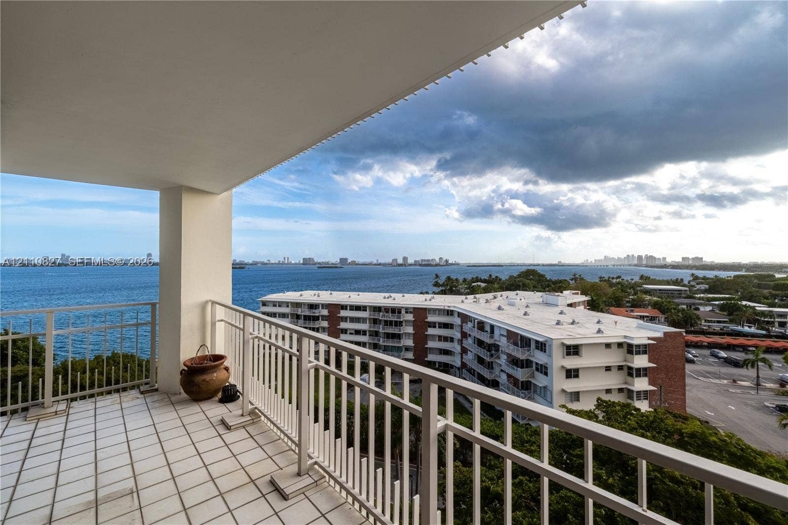 4000 Towerside Terrace, #908, Miami, Miami, FL 33138 Covered balcony featuring white tiled flooring and a metal railing, overlooking the water and shoreline