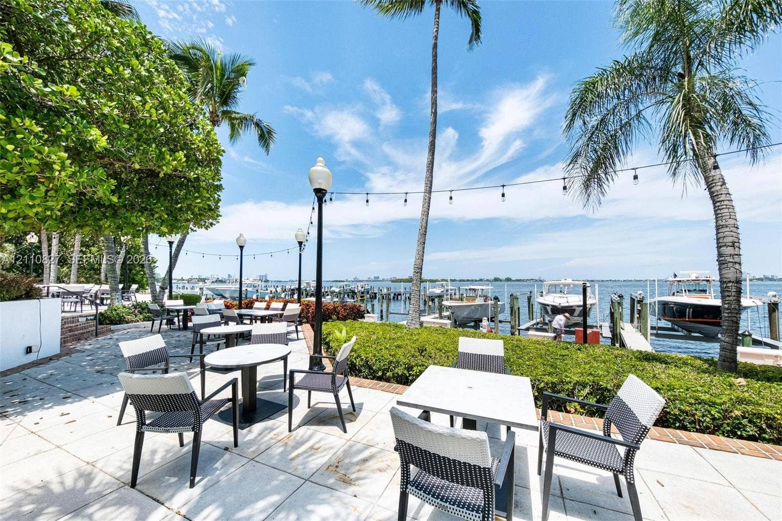 4000 Towerside Terrace, #908, Miami, Miami, FL 33138 Waterfront patio featuring stone paver flooring, integrated landscape lighting, established palm trees, and a private boat dock