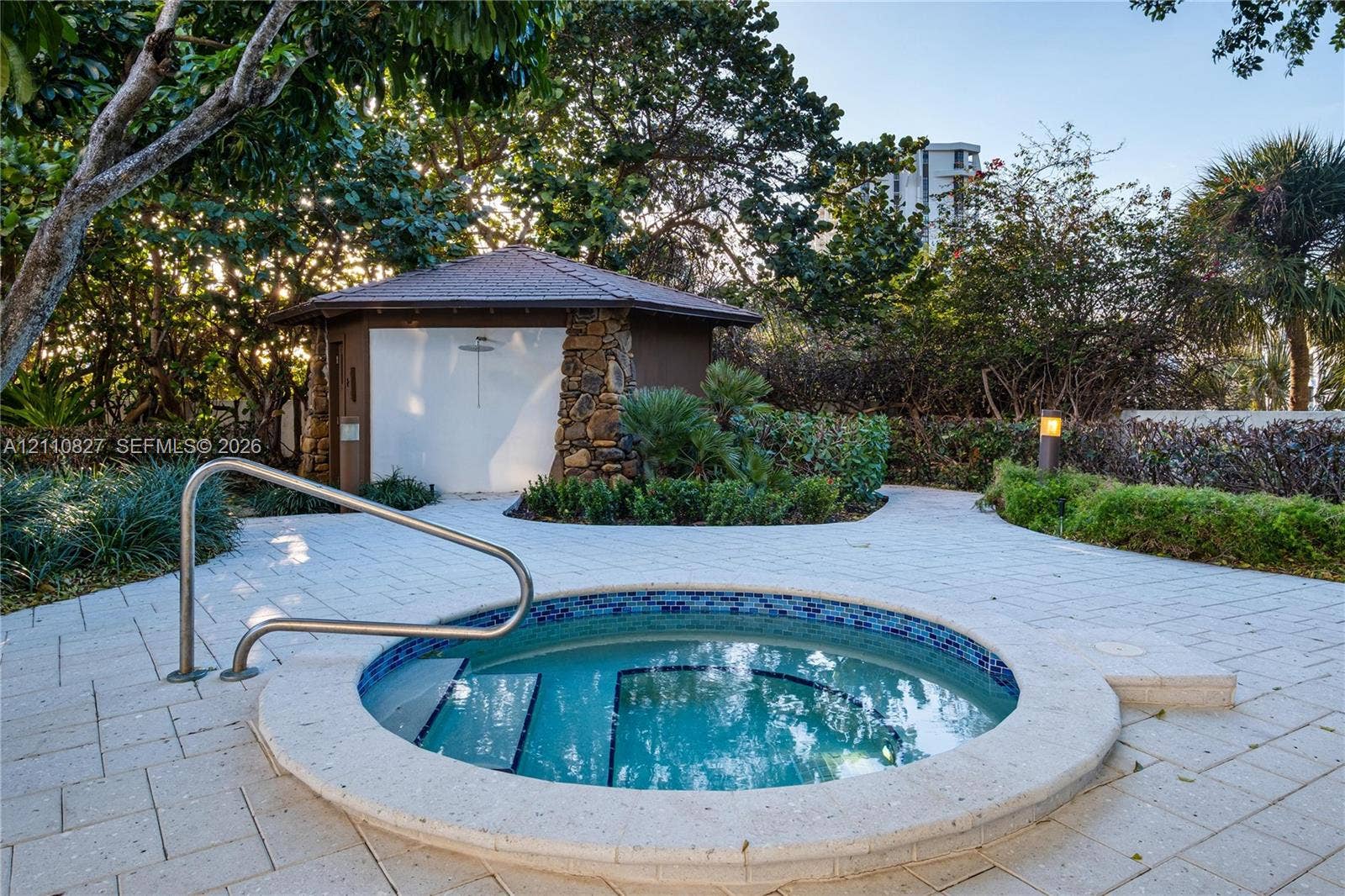 4000 Towerside Terrace, #908, Miami, Miami, FL 33138 In-ground spa with tile detailing, stone-accented cabana, integrated metallic handrail, and light-toned paver hardscaping