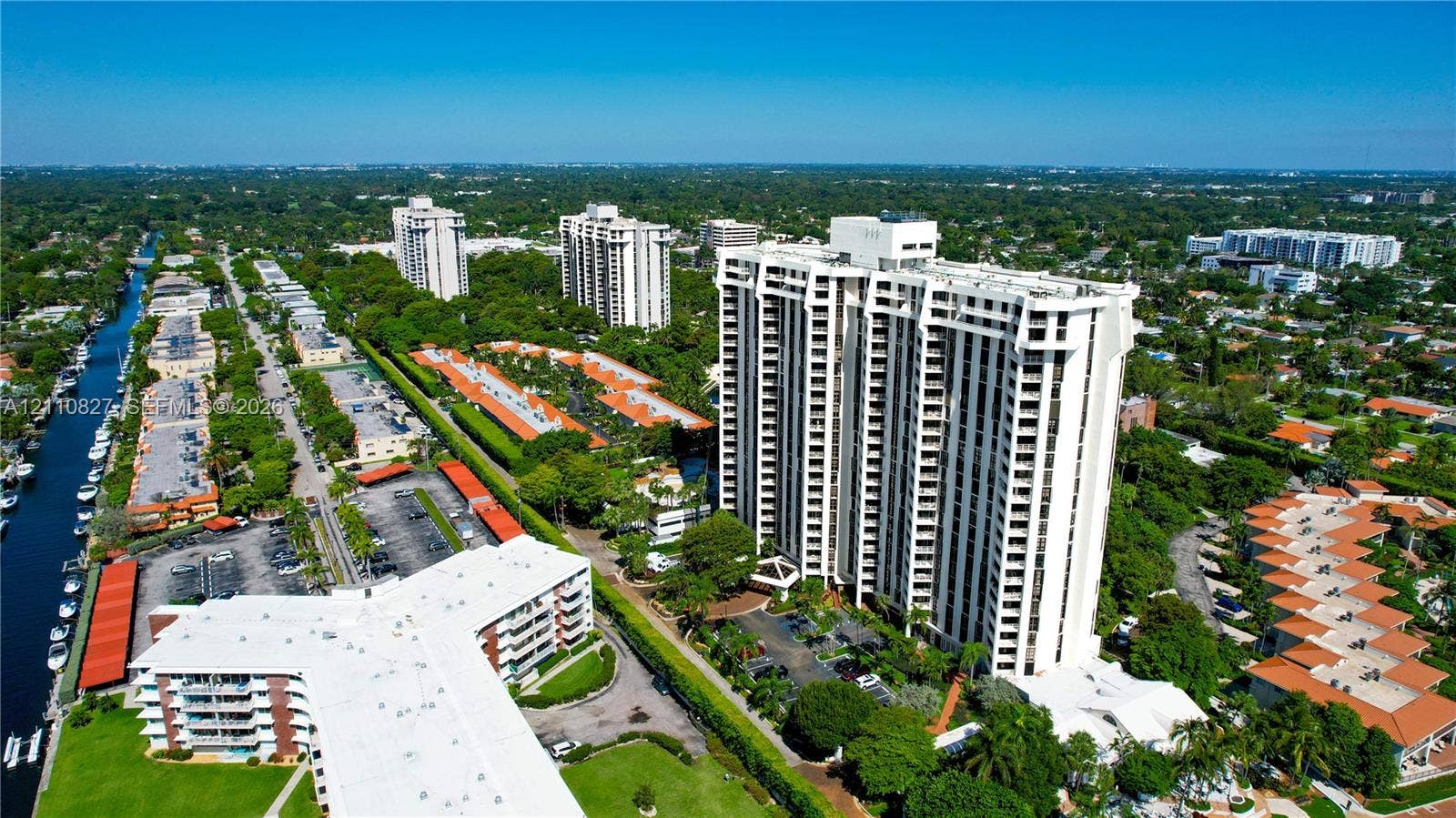 4000 Towerside Terrace, #908, Miami, Miami, FL 33138 Aerial perspective of a high-rise residential structure featuring tiered balconies, covered parking areas, manicured grounds, and immediate access to a waterway