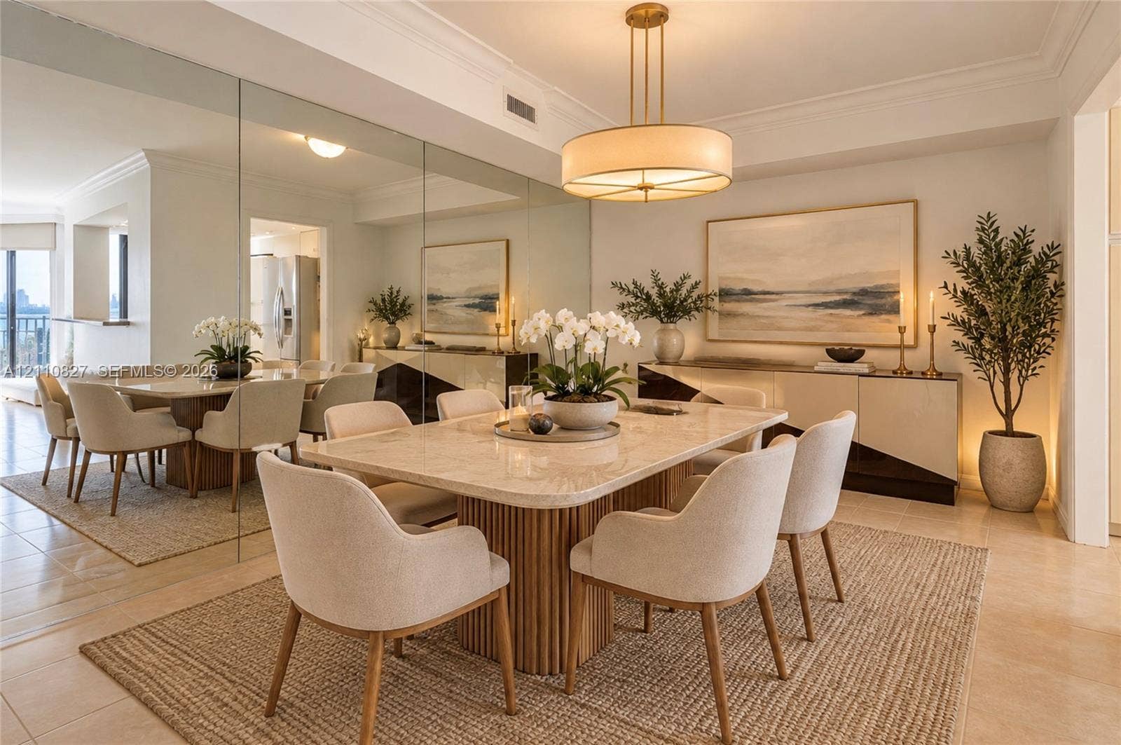 4000 Towerside Terrace, #908, Miami, Miami, FL 33138 Dining area featuring floor-to-ceiling wall mirrors, a neutral stone-top table with a fluted wooden base, and a circular drum pendant light fixture with a metallic finish